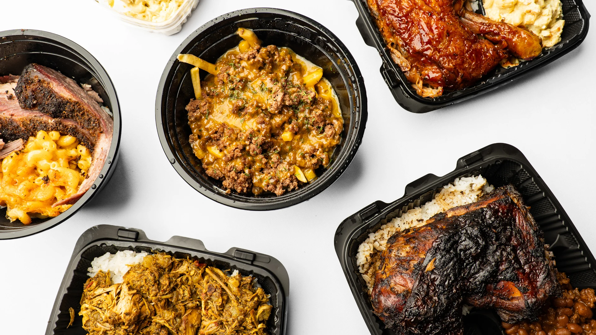 My Mama’s food spread with smoked meat, loaded fries, chicken, rice and mac and cheese